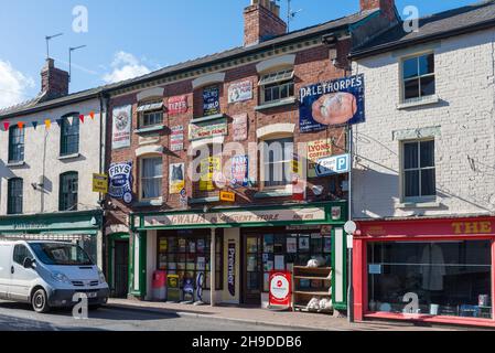 Gwalia Convenience Store in Broad Street, Ross-on-Wye, Herefordshire è decorato con numerosi vecchi cartelli pubblicitari vintage sulla parete esterna Foto Stock