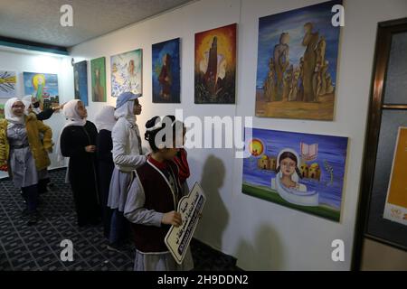 I palestinesi visitano una mostra d'arte nell'ambito di una campagna per sensibilizzare la popolazione alla violenza contro le donne, nella striscia di Gaza, il 6 dicembre 2021. Foto Stock