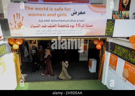 I palestinesi visitano una mostra d'arte nell'ambito di una campagna per sensibilizzare la popolazione alla violenza contro le donne, nella striscia di Gaza, il 6 dicembre 2021. Foto Stock