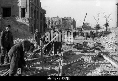 Warszawa, 1947-10. Budowa linii tramwajowej Œródmieœcie-¯oliborz. NZ. Robotnicy uk³adaj¹ rozjazdy w kierunku Leszna. W g³êbi zrujnowany pa³ac Mostowskich. ps/gr PAP Dok³adny dzieñ wydarzenia nieustalony. Varsavia, 1947 ottobre. Costruzione della linea del tram di Srodmiescie-Zoliborz. Nella foto: Lavoratori che posano il bivio in direzione del distretto di Leszno. Sullo sfondo il Palazzo Mostowskich danneggiato. ps/gr PAP Foto Stock