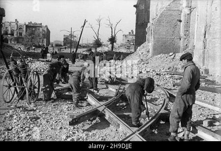 Warszawa, 1947-10. Budowa linii tramwajowej Œródmieœcie-¯oliborz. NZ. Robotnicy uk³adaj¹ rozjazdy w kierunku Leszna. W g³êbi zrujnowany pa³ac Mostowskich. ps/gr PAP Dok³adny dzieñ wydarzenia nieustalony. Varsavia, 1947 ottobre. Costruzione della linea del tram di Srodmiescie-Zoliborz. Nella foto: Lavoratori che posano il bivio in direzione del distretto di Leszno. Sullo sfondo il Palazzo Mostowskich danneggiato. ps/gr PAP Foto Stock