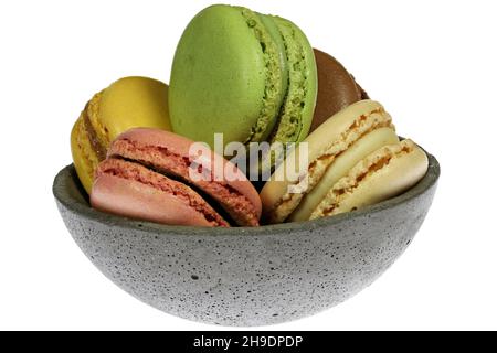 macaron colorati in una ciotola di cemento isolato su sfondo bianco Foto Stock