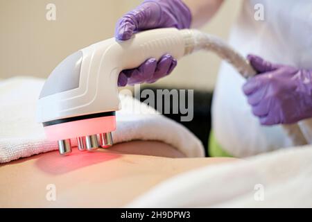 Cosmetologia hardware. Immagine concettuale delle natiche femminili ottenendo la procedura di sollevamento rf in un salone di bellezza. Primo piano Foto Stock