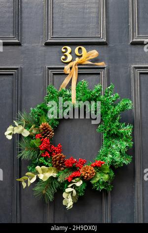 Tradizionale corona floreale di Natale sulla porta di casa a Edimburgo New Town, Scozia, Regno Unito Foto Stock