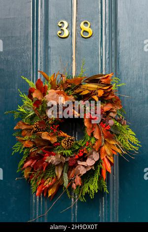 Tradizionale corona floreale di Natale sulla porta di casa a Edimburgo New Town, Scozia, Regno Unito Foto Stock