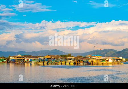 Vecchie barche di pescatori thailandesi e porto industriale nel paradiso tropicale vista panoramica del mare a Bang Rin Ranong Thailandia. Foto Stock