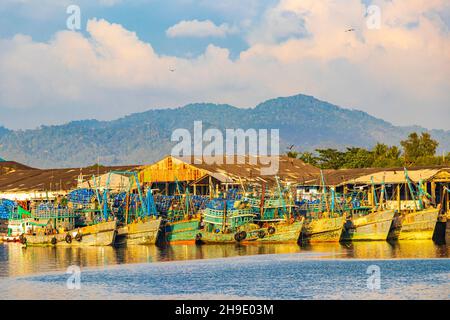 Vecchie barche di pescatori thailandesi e porto industriale nel paradiso tropicale vista panoramica del mare a Bang Rin Ranong Thailandia. Foto Stock