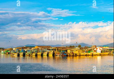 Vecchie barche di pescatori thailandesi e porto industriale nel paradiso tropicale vista panoramica del mare a Bang Rin Ranong Thailandia. Foto Stock