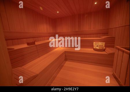 Sauna interna in legno. Ampio angolo di luce naturale. Vista perfetta sulla sauna in legno con punto luce. SALA SPA con luce calda. Foto Stock