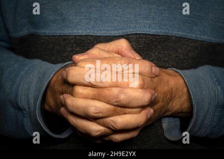 Uomo con le mani unite, vicino. Foto Stock