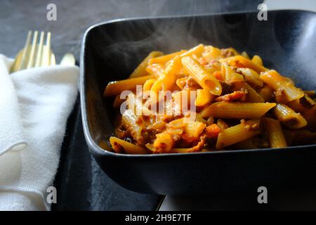 Penne ragu alla bolognese su tavola da cucina in marmo Foto Stock