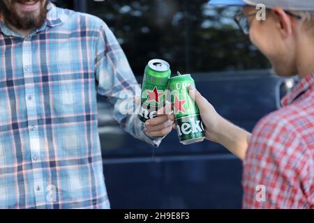 KHARKOV, UCRAINA - 31 LUGLIO 2021: Lattine di Heineken birra lager pallido nelle mani degli uomini all'aperto Foto Stock