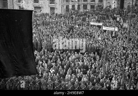 Warszawa, 1947-10-16. Stutysiêczna manifestacja na placu Teatralnym dla uczczenia pamiêci 50 ¿o³nierzy Gwardii Ludowej powieszonych przez Niemców w 1942 r. w odwecie za wysadzenie torów kolejowych. By³a a pierwsza publiczna egzekucja w okupowanej Warszawie. NZ. t³um ze sztandarami zgromadzony przed Teatrem wielkim. Pierwszy szereg tworz¹ ¿o³nierze Korpusu Bezpieczeñstwa Wewnêtrznego. W tle zrujnowany pa³ac Jab³onowskich. wb/gr PAP Varsavia, 16 ottobre 1947. Una dimostrazione forte di 100,000 in onore di 50 soldati della Guardia popolare impiccati dai tedeschi nel 1942 in rappresaglia per il loro soffio di re Foto Stock