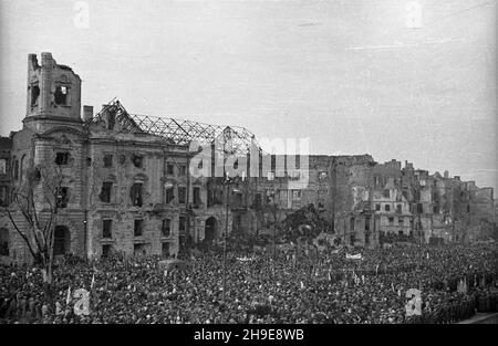 Warszawa, 1947-10-16. Stutysiêczna manifestacja na placu Teatralnym dla uczczenia pamiêci 50 ¿o³nierzy Gwardii Ludowej powieszonych przez Niemców w 1942 r. w odwecie za wysadzenie torów kolejowych. By³a a pierwsza publiczna egzekucja w okupowanej Warszawie. NZ. t³um ze sztandarami zgromadzony przed Teatrem wielkim. W tle zrujnowany pa³ac Jab³onowskich. wb/gr PAP Varsavia, 16 ottobre 1947. Una dimostrazione forte di 100,000 in onore di 50 soldati della Guardia popolare impiccati dai tedeschi nel 1942 in rappresaglia per il loro soffiaggio di binari ferroviari. Questa fu la prima esecuzione pubblica a Varsavia occupata. Foto Stock