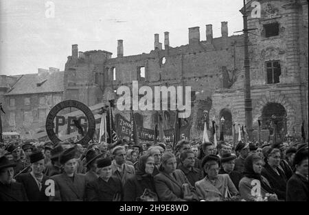 Warszawa, 1947-10-16. Stutysiêczna manifestacja na placu Teatralnym dla uczczenia pamiêci 50 ¿o³nierzy Gwardii Ludowej powieszonych przez Niemców w 1942 r. w odwecie za wysadzenie torów kolejowych. By³a a pierwsza publiczna egzekucja w okupowanej Warszawie. NZ. t³um z flagami i sztandarami zgromadzony przed Teatrem wielkim. W tle zrujnowany pa³ac Jab³onowskich. wb/gr PAP Varsavia, 16 ottobre 1947. Una dimostrazione forte di 100,000 in onore di 50 soldati della Guardia popolare impiccati dai tedeschi nel 1942 in rappresaglia per il loro soffiaggio di binari ferroviari. Questa è stata la prima esecuzione pubblica in occupato Foto Stock