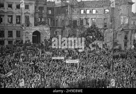 Warszawa, 1947-10-16. Stutysiêczna manifestacja na placu Teatralnym dla uczczenia pamiêci 50 ¿o³nierzy Gwardii Ludowej powieszonych przez Niemców w 1942 r. w odwecie za wysadzenie torów kolejowych. By³a a pierwsza publiczna egzekucja w okupowanej Warszawie. NZ. t³um ze sztandarami zgromadzony przed Teatrem wielkim. W tle zrujnowany pa³ac Jab³onowskich. wb/gr PAP Varsavia, 16 ottobre 1947. Una dimostrazione forte di 100,000 in onore di 50 soldati della Guardia popolare impiccati dai tedeschi nel 1942 in rappresaglia per il loro soffiaggio di binari ferroviari. Questa fu la prima esecuzione pubblica a Varsavia occupata. Foto Stock