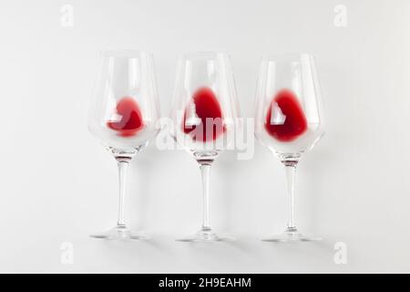 Bicchieri con vino rosso su sfondo bianco con spazio di copia. Immagine concetto di degustazione con vista dall'alto e disposizione piatta. Foto Stock