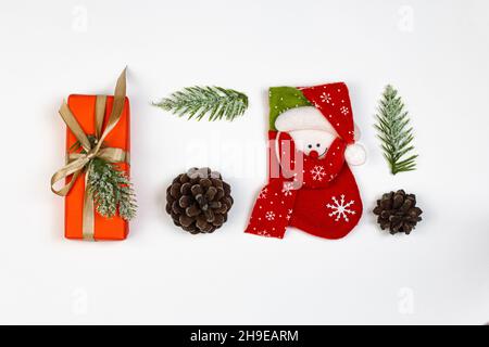 Scatola regalo, cono di abete e giocattoli decorativi dell'albero di Natale. Piatto su sfondo bianco. Concetto del tempo del partito. Foto Stock