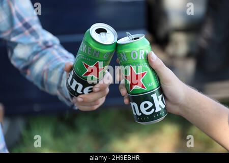 KHARKOV, UCRAINA - 31 LUGLIO 2021: Lattine di Heineken birra lager pallido nelle mani degli uomini all'aperto Foto Stock