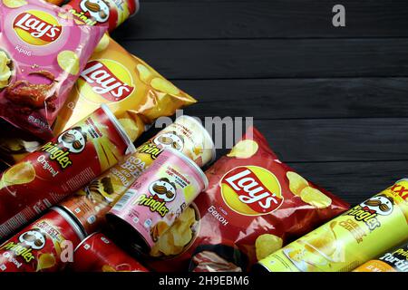 KHARKOV, UCRAINA - 3 GENNAIO 2021: Vari aromatizzati di patatine fritte di patata di Lay's e Pringles nel design classico delle confezioni. Marche di patate famose in tutto il mondo Foto Stock