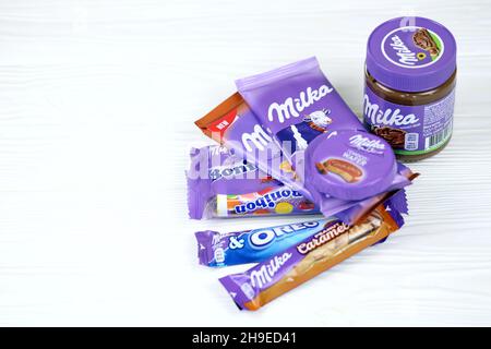 KHARKOV, UCRAINA - 2 LUGLIO 2021: Prodotti al cioccolato Milka con disegno classico a lilla su tavola di legno bianco Foto Stock