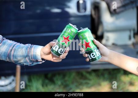 KHARKOV, UCRAINA - 31 LUGLIO 2021: Lattine di Heineken birra lager pallido nelle mani degli uomini all'aperto Foto Stock