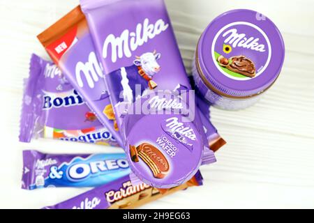 KHARKOV, UCRAINA - 2 LUGLIO 2021: Prodotti al cioccolato Milka con disegno classico a lilla su tavola di legno bianco Foto Stock