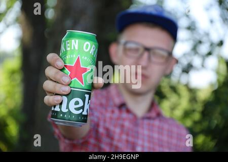 KHARKOV, UCRAINA - 31 LUGLIO 2021: Uomo con lattina verde di birra chiara di Heineken prodotta dalla birreria olandese Heineken N.V. Foto Stock