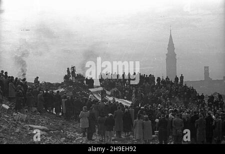 Warszawa, 1947-11-01. Msza ¿a³obna na gruzach Pawiaka w ho³dzie zamordowanym w niemieckich wiêzieniach i obozach. NZ. Delegacje organizacji spo³ecznych i rodziny pomordowanych podczas mszy. L g³êbi koœció³ œw. Augustyna. ps/gr PAP Varsavia, 1 novembre 1947. La messa funeraria in omaggio agli assassinati nelle prigioni tedesche e nei campi di concentramento offerti alle rovine di Pawiak, l'ex prigione. Nella foto: Delegazioni di opposioni sociali e famiglie degli assassinati durante la messa. Sullo sfondo la chiesa di Sant'Agostino. ps/gr PAP Foto Stock