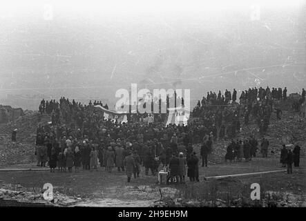 Warszawa, 1947-11-01. Msza ¿a³obna na gruzach Pawiaka w ho³dzie zamordowanym w niemieckich wiêzieniach i obozach. NZ. Ludzie zgromadzeni na mszy. Przy o³tarzu le¿¹ pasiate sztandary Zwi¹zku By³ych WiêŸniów Politycznych. ps/gr PAP Varsavia, 1 novembre 1947. La messa funeraria in omaggio agli assassinati nelle prigioni tedesche e nei campi di concentramento offerti alle rovine di Pawiak, l'ex prigione. Nella foto: Persone che frequentano la messa. Ai piedi dell'altare giacciono le bandiere con le strisce dell'Associazione degli ex prigionieri politici. ps/gr PAP Foto Stock