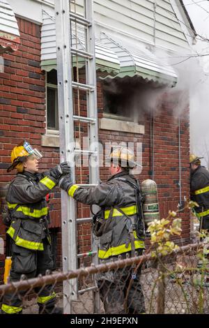 Detroit, Michigan - i vigili del fuoco hanno allestito una scala mentre combattono un incendio che ha danneggiato una casa nel quartiere Morningside di Detroit. Foto Stock