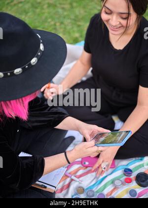 due giovani donne che guardano un design da caratterizzare al telefono Foto Stock