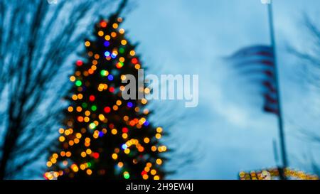 Luci astratte colorate dall'albero di natale e bandiere americane all'aperto Foto Stock