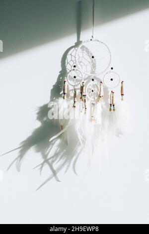 Sognare catcher su parete bianca alla luce del sole. Foto Stock