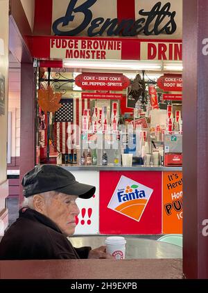 Uomo anziano con una tazza di caffè di fronte allo stand Bennett's Ice Cream presso il Farmers Market di Los Angeles, California Foto Stock