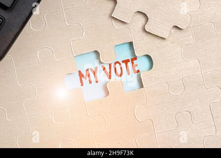 Scrittura a mano segno il mio voto, foto concettuale l'atto di mostrare la vostra scelta o opinione in un'elezione o riunione costruire un bianco incompiuto Jigsaw Pa Foto Stock