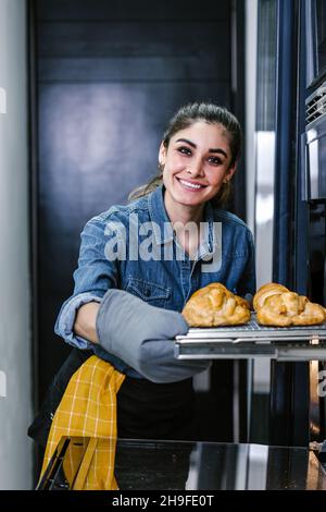 Giovane donna latina forno croissant in cucina in Messico America Latina Foto Stock