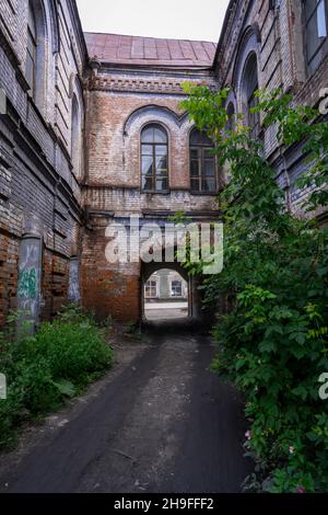 Ingresso al cortile di un edificio merchant dilapidato del 19 ° secolo nella città di Kamen-na-OB, Russia Foto Stock