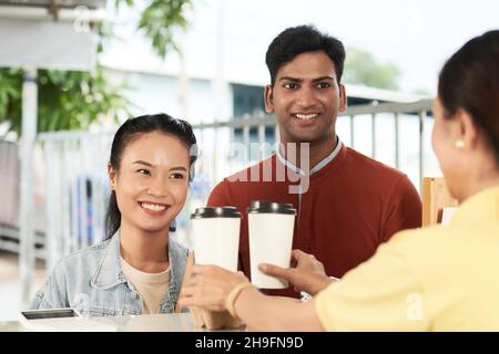 Felice diverse coppie giovani ordinare prendere il caffè in coffee shop Foto Stock