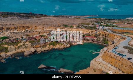 Drone aereo Panorama della pittoresca baia di Malta chiamato Popeye villaggio, ex set cinematografico e ora una bella spiaggia con case e scogliere emergenti fr Foto Stock