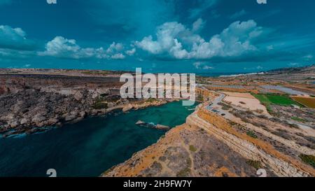 Drone aereo Panorama della pittoresca baia di Malta chiamato Popeye villaggio, ex set cinematografico e ora una bella spiaggia con case e scogliere emergenti fr Foto Stock