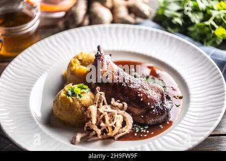 Gamba di pollo arrostita lenta su miele e zenzero, purè di patate con cipolla e coriandolo - Top of view. Foto Stock