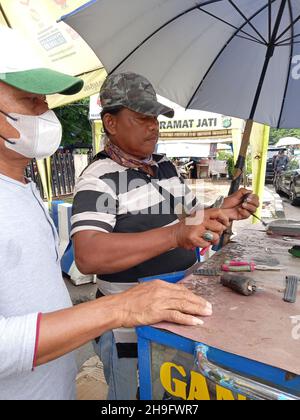 Editoriale Photo, Indonesia, Jakarta Est, Kramat Jati, 12 dicembre 2021, Uomo Riparazione o sostituzione dell'orologio da cinturino cliente Foto Stock