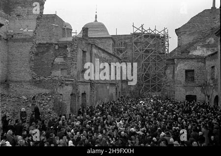 Warszawa, 1948-03-21. Uroczystoœæ przeniesienia cudownej figury Chrystusa z koœcio³a Karmelitów do kaplicy Baryczków w katedrze œw. Jana Chrzciciela na Starym Mieœcie. Wierni s³uchaj¹ kazania sekretarza generalnego Konferencji Episkopatu Polski biskupa Zygmunta Choromañskiego pomiêdzy ruinami katedry. wb PAP Varsavia, 21 marzo 1948. La cerimonia di trasferimento della figura miracolosa di Cristo dalla Chiesa Carmelitana alla Cappella Baryczkow nella Cattedrale di San Giovanni nella Città Vecchia. Nella foto: I fedeli ascoltano il vescovo Zygmunt Choromanski, segretario generale della Conferenza di Pol Foto Stock