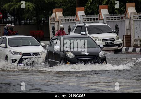 Makassar, Sulawesi meridionale, Indonesia. 7 Dic 2021. Un certo numero di veicoli passa durante il tempo estremo nella città di Makassar. Il clima estremo che si è verificato per diversi giorni a Makassar City ha fatto un certo numero di strade allagate. (Credit Image: © Herwin Bahar/ZUMA Press Wire) Foto Stock