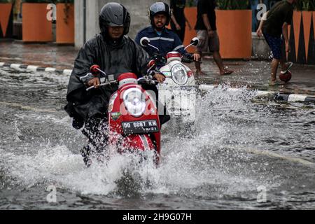 Makassar, Sulawesi meridionale, Indonesia. 7 Dic 2021. Un certo numero di veicoli passa durante il tempo estremo nella città di Makassar. Il clima estremo che si è verificato per diversi giorni a Makassar City ha fatto un certo numero di strade allagate. (Credit Image: © Herwin Bahar/ZUMA Press Wire) Foto Stock