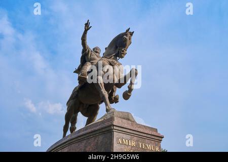 La grande statua di bronzo, scultura di Amir Timur su un cavallo. Divertente, un uccello sul suo dito. Nel centro di Tashkent, Uzbekistan. Foto Stock