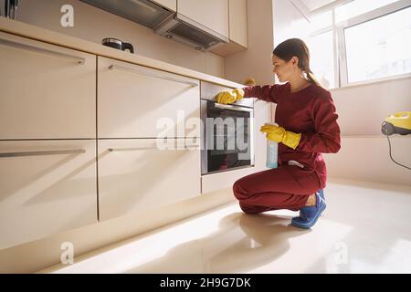 Attrezzatura per la pulizia della cucina del giovane janitor con panno in microfibra Foto Stock