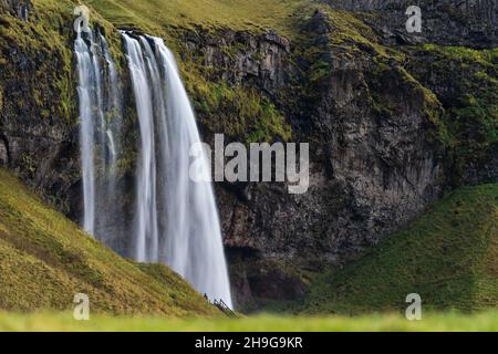 Seljalandfoss cascata in Islanda lunga esposizione con turista Foto Stock