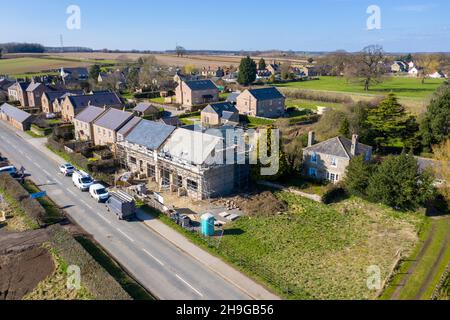 Foto aerea del villaggio britannico di Wetherby nello Yorkshire mostrare i lavori di costruzione di un edificio in corso su una proprietà in il villaggio con impalcatura in su Foto Stock